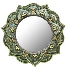 a mirror that is sitting on top of a white surface with green and yellow accents