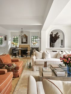 a living room filled with lots of furniture and flowers in vases on the coffee table