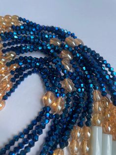 Double Strand Waist Bead "Koffikro" features two strands adorned with rich, deep blue glass seed beads. Dive into the enchanting allure of this accessory, designed to add a touch of sophistication and mystery to your style. 🌌 Blue : Immerse yourself in the deep and luxurious shades of blue that adorn each strand of this waist bead. The profound color symbolizes tranquility and depth, making it a perfect choice for expressing your inner calm and timeless elegance. 🌟 Double Strand: The double strand design adds a layer of opulence and texture, creating a visually stunning and intricate accessory. The strands cascade gracefully, allowing you to make a bold and refined statement with every movement. 🔵 Versatile Expression: Whether worn under clothing for a discreet touch or as a visible sta Bohemian Blue Glass Beads, Blue Glass Beaded Necklaces, Blue Beaded Bracelets With Spacer Beads For Party, Blue Polished Glass Beads, Blue Oval Faceted Bead Jewelry, Blue Glass Polished Beads, Blue Glass Spiritual Beads, Spiritual Blue Glass Beads, Blue Polished Beads For Beach