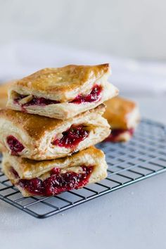 three scones stacked on top of each other on a cooling rack with cranberry sauce