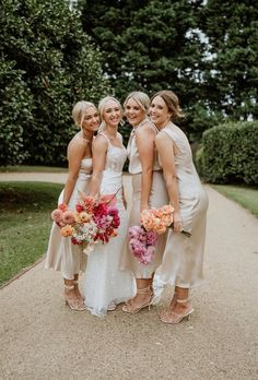 four bridesmaids are posing for a photo together