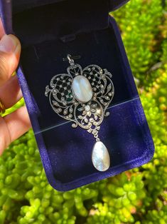 This is an antique silver statement pendant of delicate craftsmanship, made in the UK in the 1860s (the Victorian era). The pendant is decorated with natural blister pearls, a wild pearl, and many tiny Marcasite crystals. It has a 925 silver hallmark on the back. Pendant size: approx. 47x74 mm Silver is marked as 925 silver. *This necklace was made over 100 years ago, please bear with the signs of wear and wear it gently. You'll receive the pendant shown in the pictures. Vintage White Gold Jewelry With Pearl Pendant, Antique Teardrop Pendant Jewelry For Wedding, Vintage White Gold Jewelry With Pearl Drop, Antique White Gold Necklace With Pearl Pendant, Ornate Pearl Drop Jewelry As Gift, Ornate Pearl Drop Jewelry Gift, Victorian Large Pendant Necklace For Weddings, Pearl Oval Pendant Jewelry For Wedding, Oval Large Pendant Jewelry For Wedding