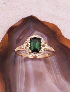 CJ126487 Maine tourmaline ring. Vintage inspired 14k yellow gold ring featuring an exquisite emerald-cut Maine green tourmaline from Mount Mica mine in Paris, Maine.  Surrounding this mesmerizing tourmaline is a delicate scroll frame. Small, sparkling diamonds adorn the shank of the ring. Whether you're drawn to the rich green hue of the tourmaline or the intricate details of the setting, there's no denying the allure of this piece. Tourmaline is 7x5mm, .92cts. Diamonds approximately 1mm each, natural, SI clarity. Currently the ring is size 7, we will resize at no extra charge. Please specify ring size at checkout if resizing is needed. Yellow Gold Tourmaline Emerald-cut Ring, Rich Green, Tourmaline Ring, Yellow Gold Ring, Green Tourmaline, Ring Vintage, Sparkle Diamonds, Work Outfits, Yellow Gold Rings