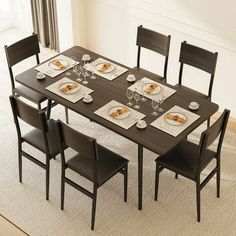 a dining room table set with place settings