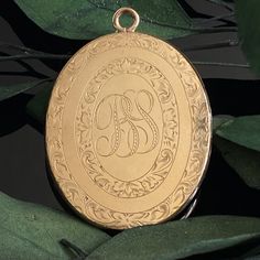 "Antique Victorian to Edwardian era large oval gold filled monogram locket with engraved initials on the interior (possibly the makers' mark). Includes one original frame.   Monogram on front appears to be \"BS\" while the interior is engraved \"JFSS.\" Good condition with typical signs of age and wear. Measures approx. 1.55\" x 1.25\"" Oval Locket Necklace With Engraving Option For Wedding, Classic Oval Locket Necklace With Engraving, Classic Oval Locket Necklace With Engraving Option, Classic Gold Locket Necklace With Engraving Option, Gold Classic Locket Necklace With Engraving Option, Classic Oval Locket Necklace For Memorial, Antique Gold Oval Locket Necklace For Anniversary, Heirloom Oval Engraved Locket Necklace, Heirloom Oval Locket Necklace For Memorial