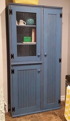 a blue cabinet in the corner of a room with a yellow towel on top of it