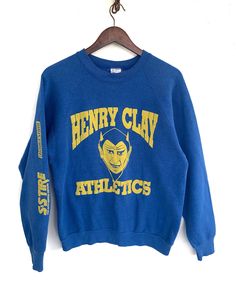 "Vintage Henry Clay Athletics  Stain ( Refer pictures ) Sw110 Measurements: Width (armpit to armpit): 21\" Length (shoulder to end of garment):  25.5\" All measurements are taken with the garment flat on the ground. Refer picture carefully  Condition: Stain THANK YOU" Retro Crew Neck Pre-shrunk Top, Vintage Pre-shrunk Sweatshirt For Fan Merchandise, Vintage Pre-shrunk Sweatshirt For Fans, Pre-shrunk Vintage Sweatshirt For Fans, Retro Cotton Pre-shrunk Sweatshirt, Varsity Crew Top With Graphic Print, Retro Blue Sweatshirt With Screen Print, Retro Cotton Sweatshirt With Screen Print, Retro Cotton Sweatshirt With Graphic Print