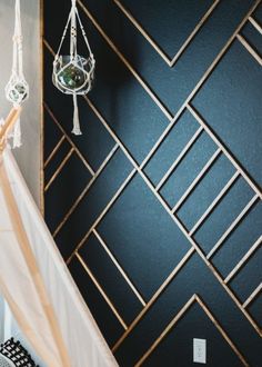 a black and white room with geometric wallpaper, chandelier hanging from the ceiling