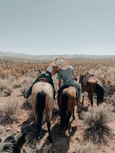 two men are riding horses in the desert