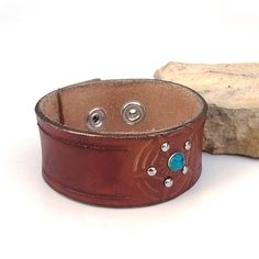 "Hand painted and stamped leather cuff bracelet for women with turquoise rivet The cuff is 32 mm wide Please check measurements before ordering. If you need a diferent size, please let me know after purchase in \"note for seller\". Please visit to my another shop: https://www.etsy.com/shop/JeansBelt?ref=hdr_shop_menu Thanks and happy shopping" Western Style Brown Cuff Bracelet As Gift, Adjustable Stamped Leather Cuff Bracelet, Stamped Leather, Leather Cuff Bracelet, Cuff Jewelry, Leather Cuffs Bracelet, Leather Cuffs, Wristbands, Bracelet For Women