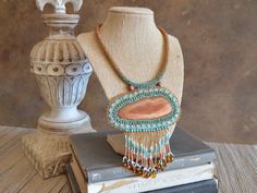 "One of a kind huge bead embroidery statement necklace / earthy Western feel / Artisan handmade dyed agate / beaded rope, beaded toggle You are sure to stand out in a room when you enter wearing this one of a kind statement necklace! Truly no one else will have it because there is only one and you've got it! Featured on this necklace is a focal pendant made of intricate bead embroidery surrounding a beautiful piece of sliced agate. Lots of different kinds of tiny beads. The fringe is made of mor Handmade Bohemian Beaded Pendant Necklaces, Artisan Handwoven Beaded Necklace, Bohemian Handmade Beaded Pendant Necklaces, Handmade Brown Beaded Long Necklaces, Handmade Brown Beaded Long Necklace, Handmade Brown Long Beaded Necklaces, Bohemian Hand Knotted Agate Jewelry, Bohemian Hand-knotted Agate Jewelry, Earthy Turquoise Beaded Necklace