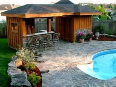 a backyard with a pool, patio and hot tub in the middle of it's yard