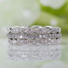 two wedding bands with white diamonds on the top and bottom, sitting next to each other