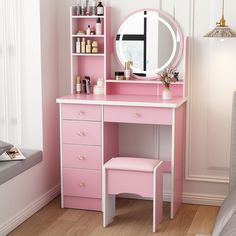 a pink vanity with a mirror and stool