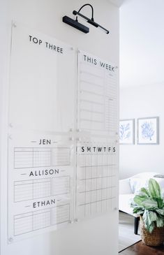 a white board with writing on it next to a potted plant