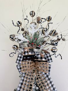 a christmas tree decorated with black and white plaid ribbon