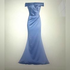 a blue dress hanging on a wall in front of a white background with an image of a woman's gown