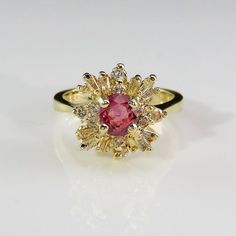 A beautiful precious earth mined pink sapphire and fine white diamond engagement ring dating to the mid century era crafted in 14K yellow gold. This classic ring designed as a ballerina style cluster setting is of heirloom quality. The beautiful pink sapphire itself has a unique pink color with just a hint of violet. The color is soft and feminine but definitely not ice cream it's more like the most exquisite dusty rose you could imagine. It weighs 5 grams. Currently it is a size 6 to 6 1/8 US. Classic Pink Diamond Cluster Ring, Pink Cluster Rings With Brilliant Cut, Classic Pink Cluster Ring With Center Stone, Elegant Pink Cluster Ring With Brilliant Cut, Pink Cluster Ring With Brilliant Cut, Pink Cluster Diamond Ring With Center Stone, Pink Brilliant Cut Cluster Ring, Classic Pink Cluster Ring With Halo Setting, Exquisite Pink Diamond Ring With Accent Stones