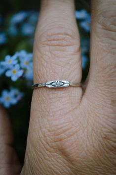 These hand hammered sterling silver stacking bands feature the sweetest little forget me not flower. Don't forget to chose your size at checkout. This piece is made to order by me in my studio in Massachusetts. Please allow up to three weeks turn around time for your piece to be made. Please ask any and all questions before purchasing. I'm happy to answer them! This item is handmade, there may be slight variations or imperfections. Delicate Promise Jewelry, Dainty Hypoallergenic Stackable Promise Rings, Delicate Flower Stackable Rings For Anniversary, Dainty Hand Stamped Stackable Rings For Anniversary, Dainty Promise Flower Ring With Birth Flower, Dainty Stackable Flower Ring As Gift, Dainty Nickel-free Promise Ring, Dainty Hand Stamped Sterling Silver Rings, Tiny Sterling Silver Stackable Promise Rings