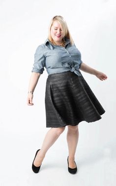 a woman in a skirt is posing for the camera