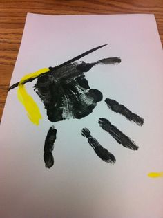 a child's handprint is shown on a piece of paper with yellow tape