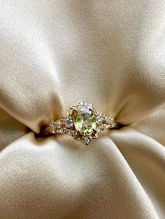 an engagement ring on top of a satin fabric