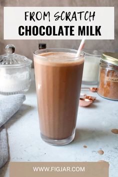 a glass filled with chocolate milk sitting on top of a table