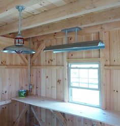 two lights hanging from the ceiling in a room with wood paneling and wooden walls