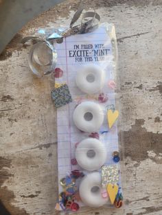 three white doughnuts are sitting on a piece of paper with some tags attached to them