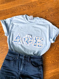 a t - shirt with the word aoa printed on it sits next to jeans