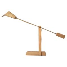 a wooden desk lamp with two metal lamps on each arm and one light is turned on