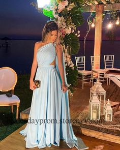 a woman in a blue dress standing next to a gazebo with flowers on it