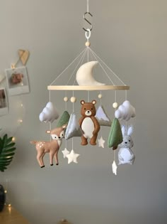 a baby mobile with stuffed animals hanging from it's sides and the moon in the background