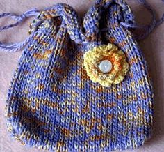 a small blue and yellow bag with a flower on the front, sitting on a white surface