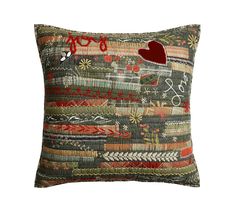 a decorative pillow with an embroidered heart on the front and back, in multicolored fabric