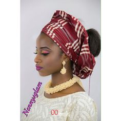 an african woman wearing a red and white head wrap with her hair in a bun