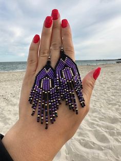 Adorn your fall outfit with these statement beaded earrings with fringe. Inspired by tribal style, these artisan seed bead earrings will sparkle with every move. These waterfall earrings have bright abstract design in black, purple and gold. It is a great finding for those who's looking for Halloween earrings as well as bohemian jewelry for autumn season. 100% top quality handmade earrings.  Length: 3.54''/ 9 cm Width: 1.18'' / 3 cm Materials:  - Czech seed beads - stainless steel accessories. The real color of the item may be slightly different from the picture shown on website caused by the brightness of your monitor. If you have special size requirements, please send me a letter about it, as this can be made to order. More beadwork earrings: https://etsy.me/30peGhg Back to shop: https:/ Purple Seed Bead Earrings, Purple Beaded Fringe Earrings For Gift, Purple Beaded Fringe Earrings For Festivals, Purple Bohemian Beaded Dangling Earrings, Purple Fringe Earrings, Unique Purple Beaded Earrings, Purple Beaded Earrings, Bead Things, Waterfall Earrings