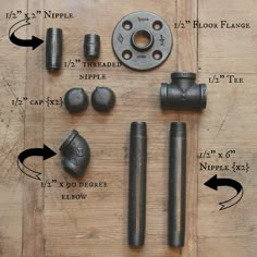 an assortment of metal fittings laid out on a wooden table with numbers and measurements