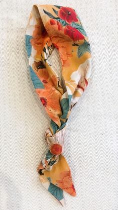 an orange and blue flowered tie on top of a white sheet