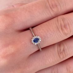 a woman's hand with a diamond and sapphire ring