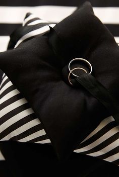 a black and white striped pillow with a ring on it