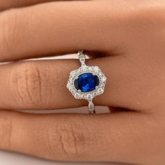 a woman's hand with a blue and white diamond ring