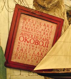 a sailboat is sitting next to a framed sign with words written in red on it