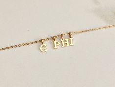 a gold plated necklace with the word phi on it