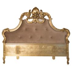 a gold colored bed frame with an ornate headboard