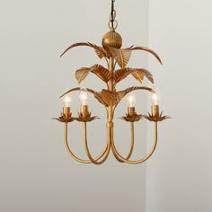 a gold chandelier with five lights hanging from it's center and leaves on the bottom