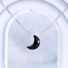 A subtly beautiful necklace for the minimalist who appreciates healing gemstones. This handmade pendant necklace features a carved black onyx crescent moon suspended from a delicate sterling silver chain - simple yet striking. Black onyx, a calming stone, lends an air of serenity when worn close to the heart. The sterling silver chain is cool and lightweight, ideal for everyday wear that doesn't demand attention yet flatters with understated elegance. An effortlessly chic accessory for the modern mystic. Materials: Black Onyx, 925 sterling silverChain length: 18 in adjustable any length shorter Jewelry Care: See more information about how to care for your jewelry here. Shipping Policy: Orders will be shipped within 1-3 business days. Economy shipping will take 7-14 days to arrive and stand Elegant Black Necklace With Moon Charm, Minimalist Moon Shaped Gemstone Necklace, Elegant Black Crescent Necklace, Black Sterling Silver Jewelry With Moon Charm, Black Moon Phase Round Pendant Jewelry, Black Moon Charm Round Pendant Jewelry, Black Round Pendant Jewelry With Moon Charm, Black Sterling Silver Necklace With Moon Charm, Black Crescent Necklaces As Gift