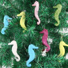 seahorse ornaments are hanging from a christmas tree