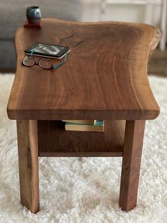 a wooden table with glasses and a cell phone sitting on it's side shelf