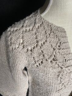 the back of a knitted sweater on a mannequin